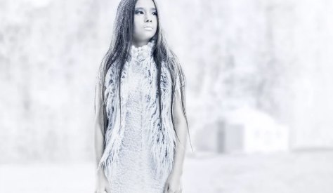 Model in witte jurk in een bleke, sterk bewerkte omgeving
